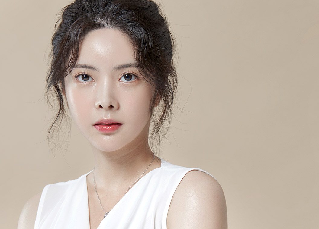 베이지 바탕 앞 올림머리 여성 모델 정면 얼굴